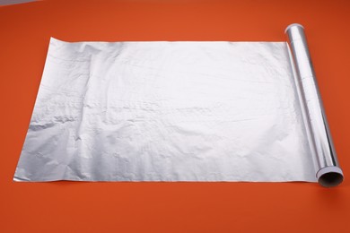 Roll of aluminum foil on orange background