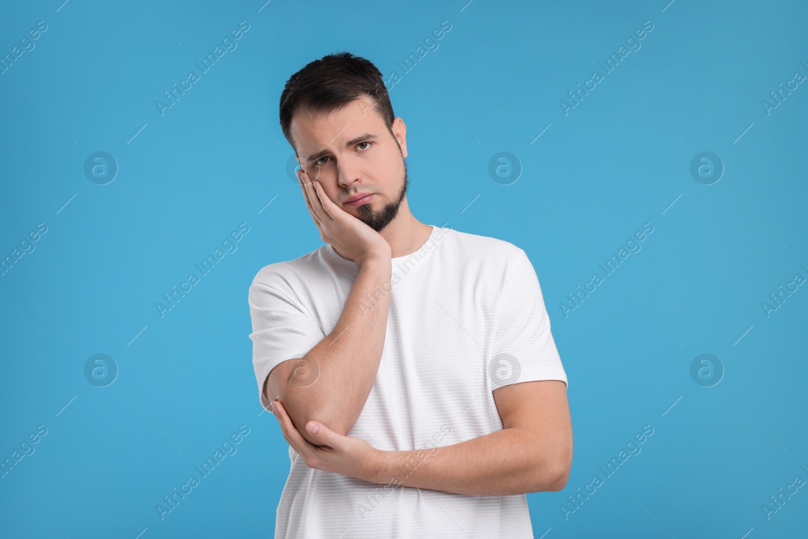 Photo of Portrait of sad man on light blue background