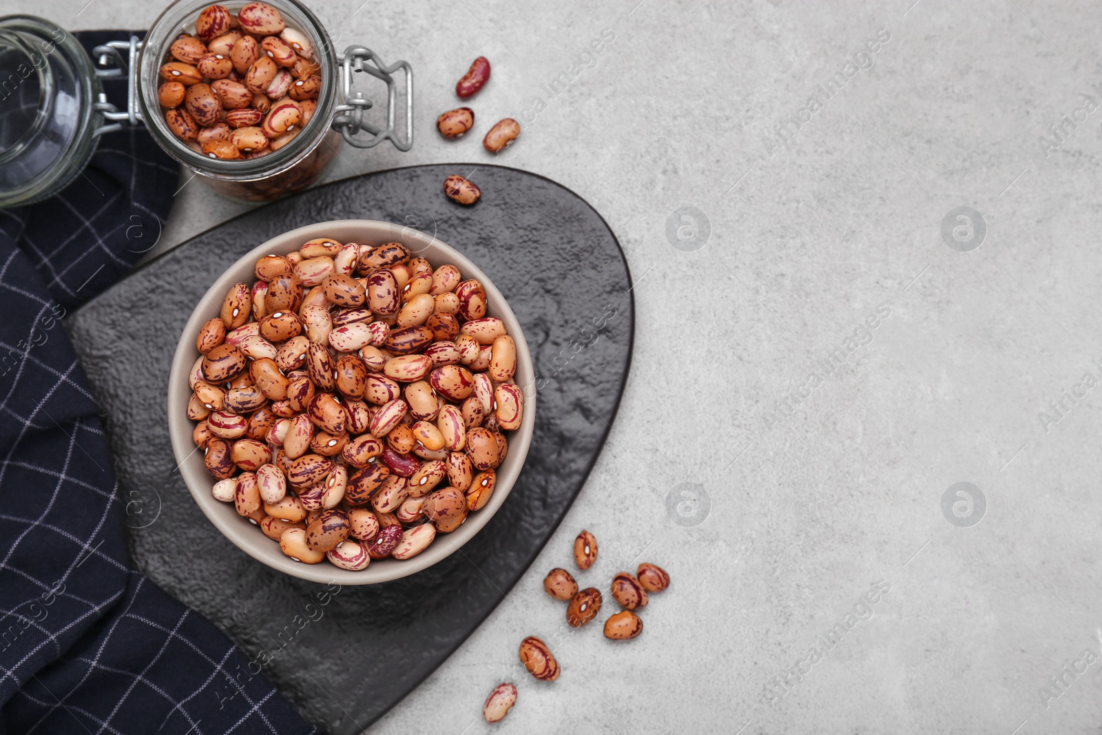 Photo of Many dry kidney beans on light grey table, flat lay. Space for text