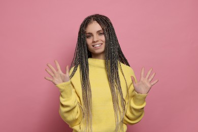 Photo of Young woman giving high five with both hands on pink background