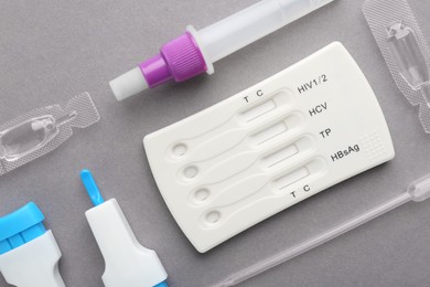 Disposable multi-infection express test kit on grey background, flat lay