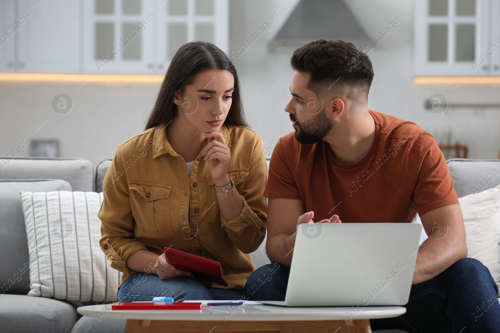 Photo of Young couple discussing family budget at home