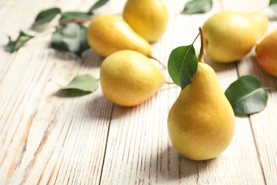 Photo of Ripe pears on wooden table. Space for text