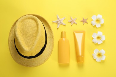 Photo of Sun protection products, hat and beach items on yellow background, flat lay