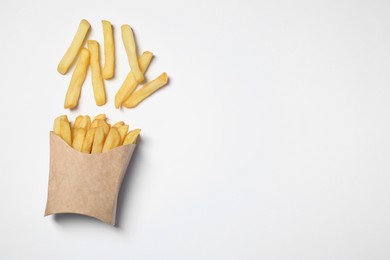 Photo of Paper cup with French fries on white table, flat lay. Space for text