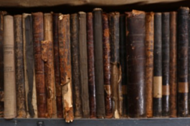 Photo of Blurred view of different library books on shelf, closeup