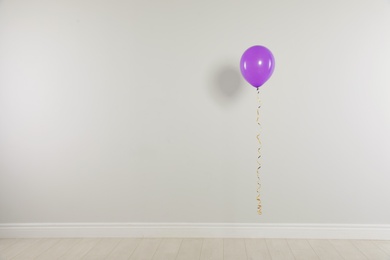 Bright balloon against light wall, space for text. Celebration time