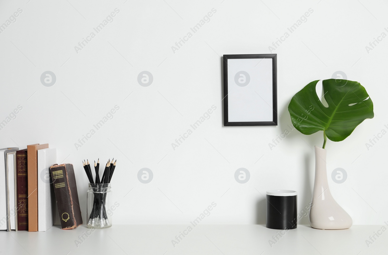 Photo of Comfortable workplace with white desk near wall