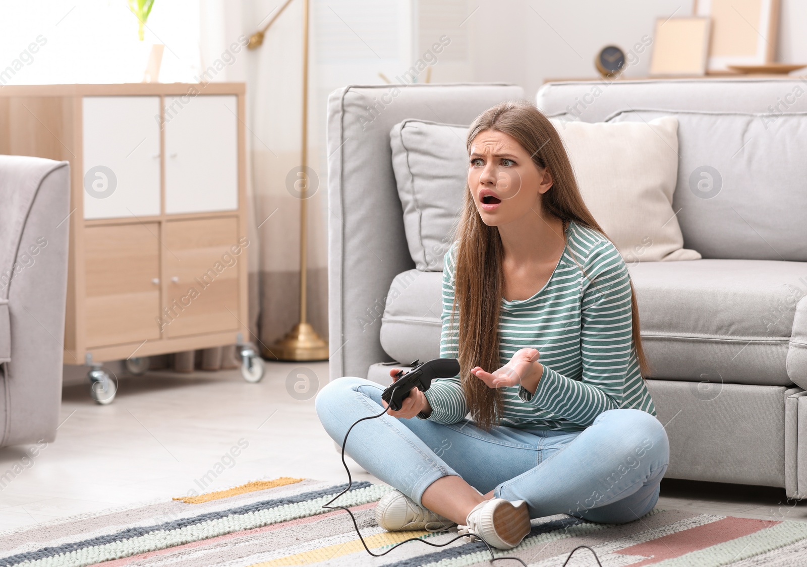 Photo of Emotional young woman playing video games at home