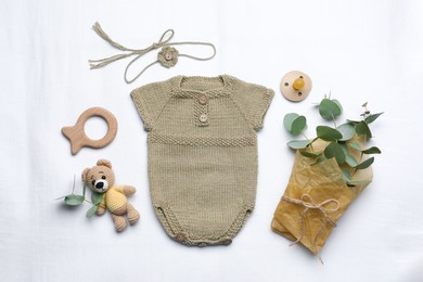 Flat lay composition with child's clothes and accessories on white fabric