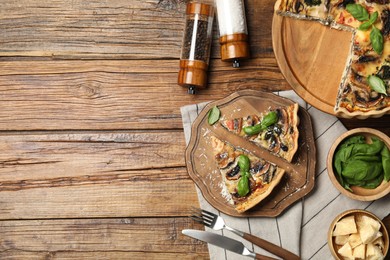 Delicious quiche with mushrooms and ingredients on wooden table, flat lay. Space for text