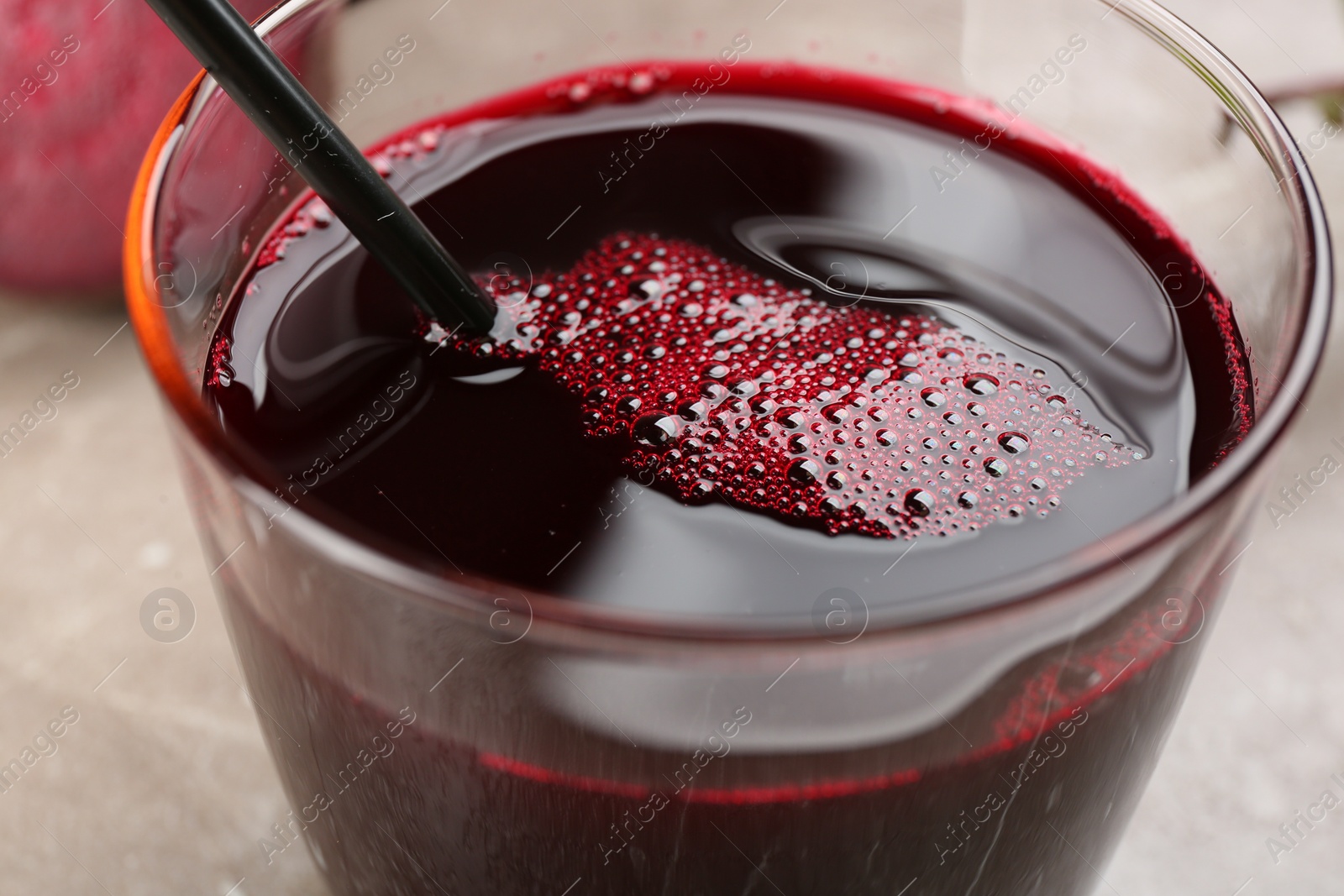 Photo of Freshly made beet juice in glass on table, closeup