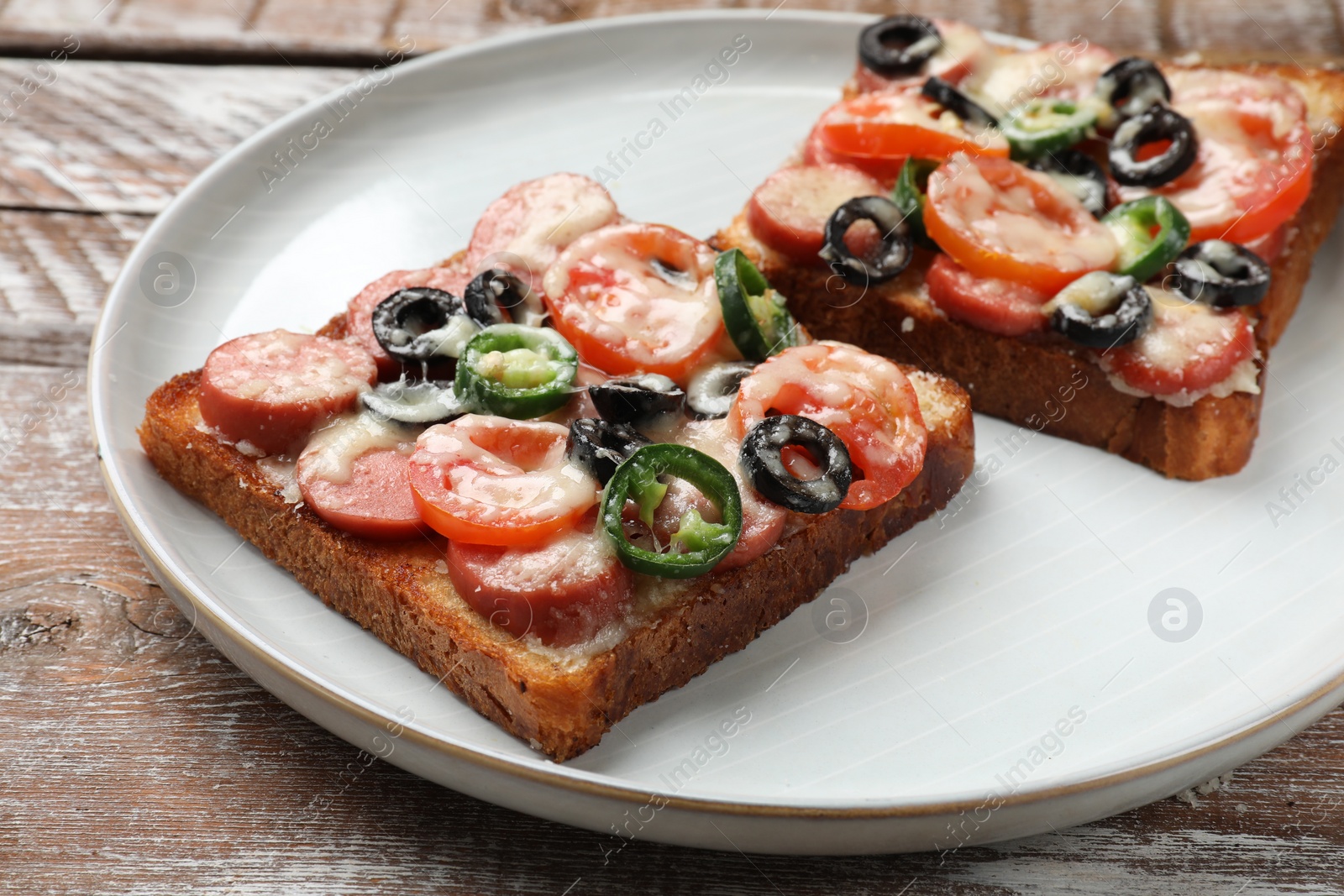 Photo of Tasty pizza toasts on wooden table, closeup