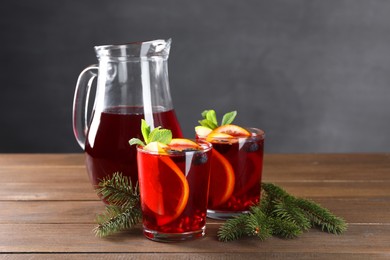 Aromatic Christmas Sangria drink and fir branches on wooden table