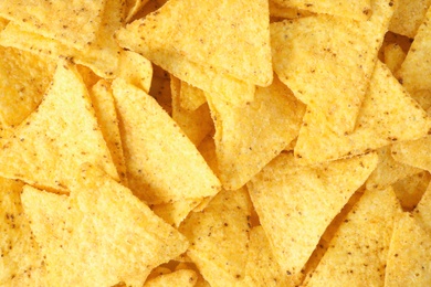 Photo of Tasty Mexican nachos chips as background, top view