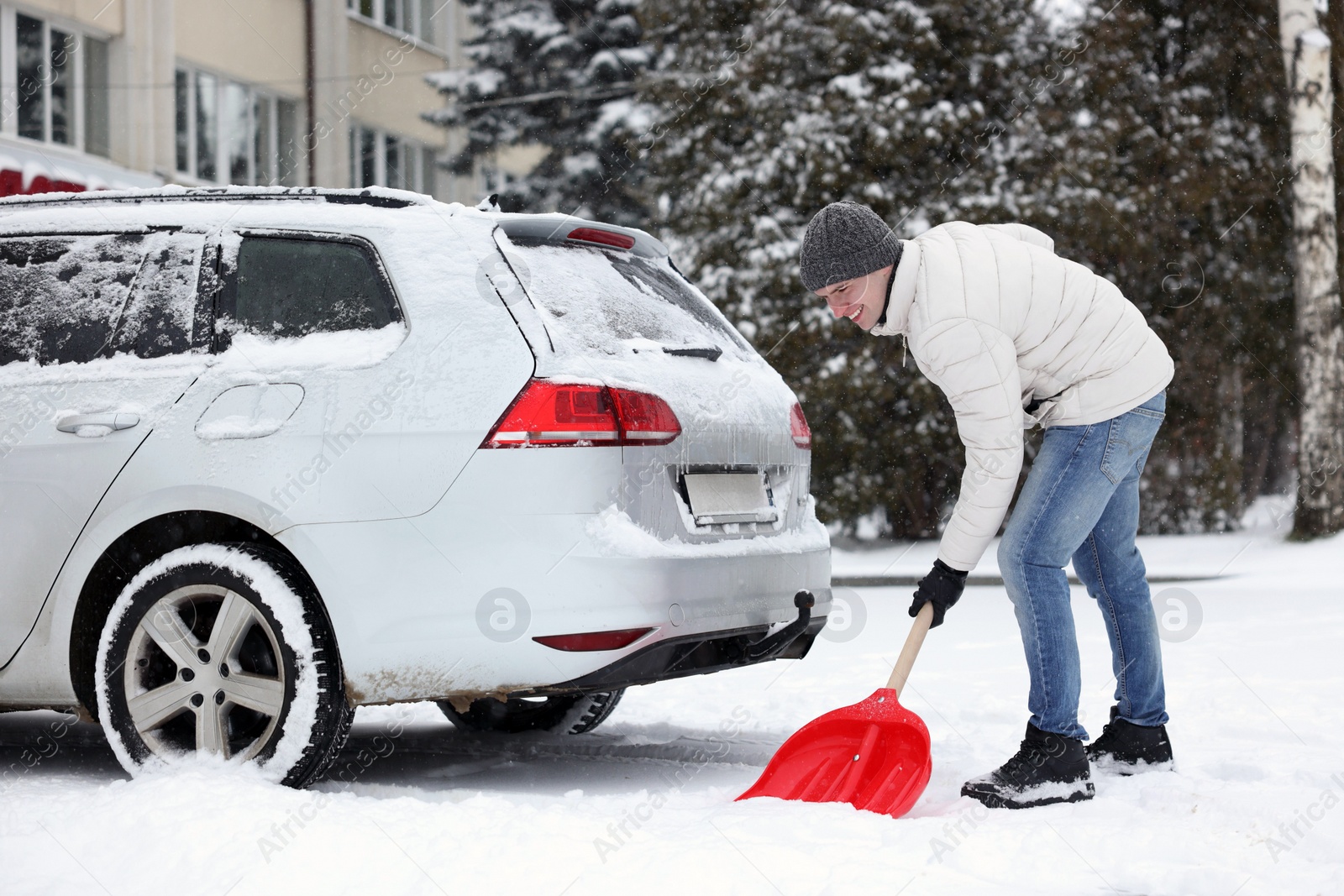 Photo of Man removing snow with shovel near car outdoors