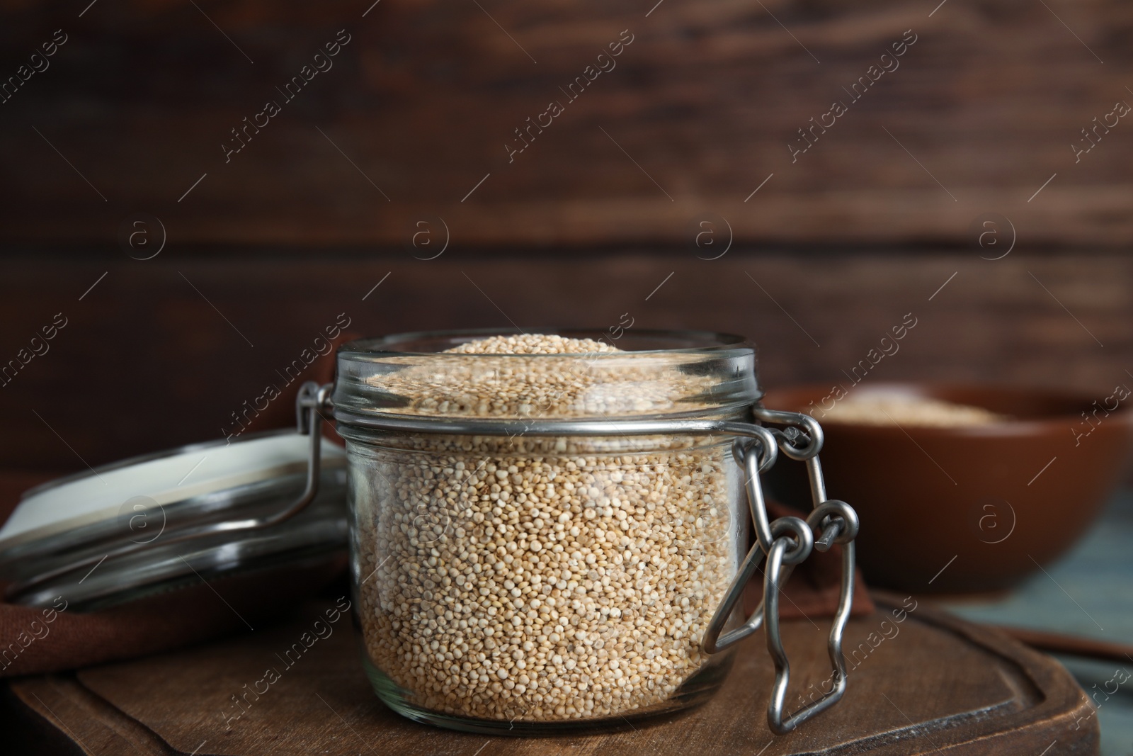 Photo of Jar with white quinoa on wooden board