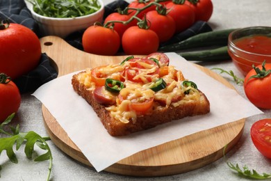 Photo of Tasty pizza toast, tomatoes and sauce on grey table