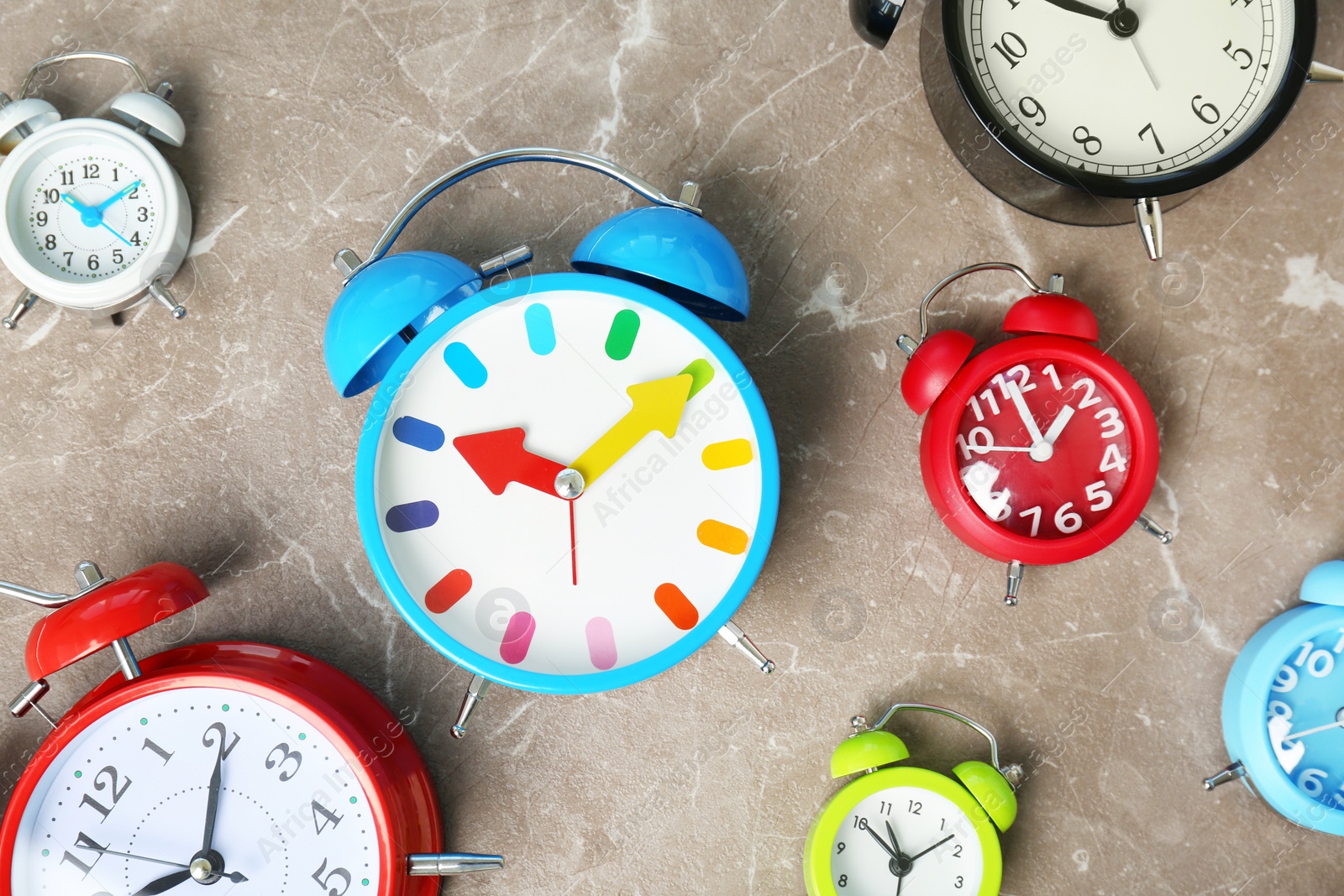 Photo of Many different alarm clocks on table. Time change concept