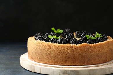 Photo of Delicious cheesecake decorated with blackberries on table