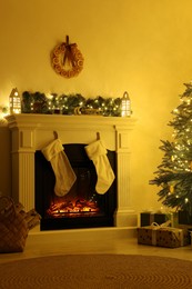 Photo of Stylish fireplace with Christmas decorations in cosy room