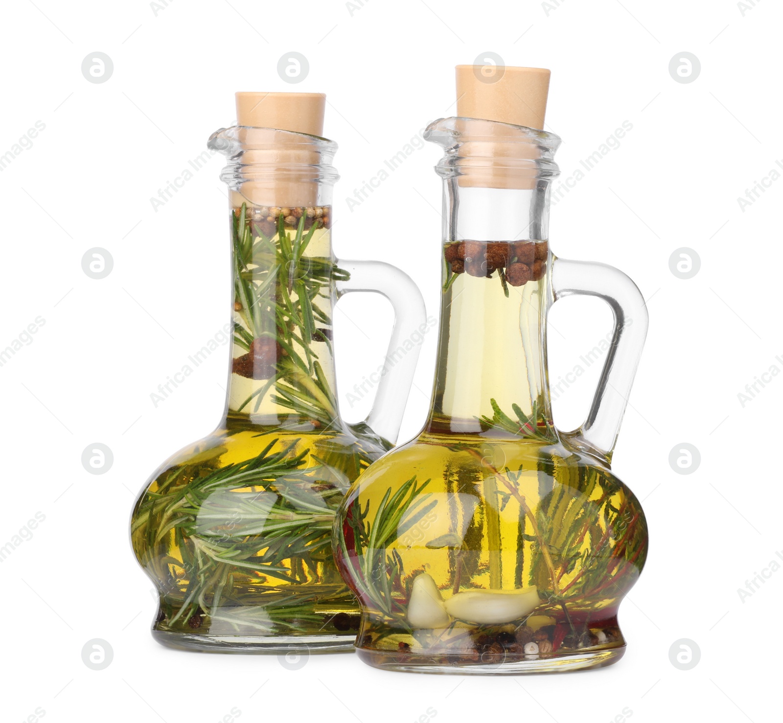 Photo of Glass jugs of cooking oils with spices and herbs on white background