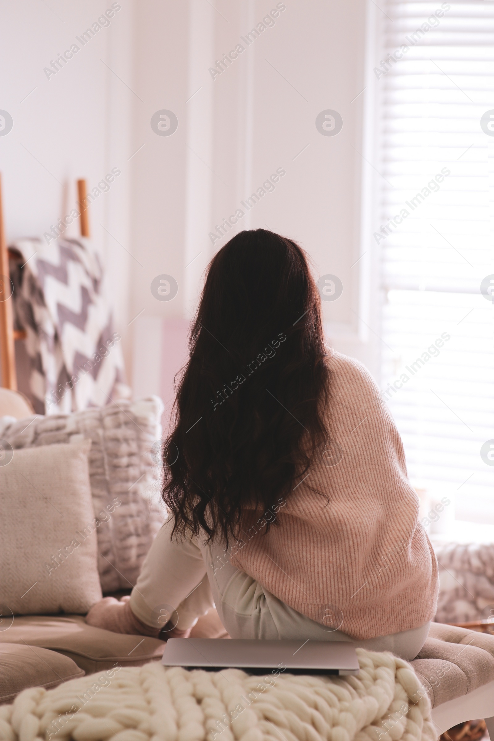 Photo of Woman relaxing at home, back view. Cozy atmosphere