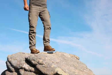 Tourist climbing on cliff, closeup of legs