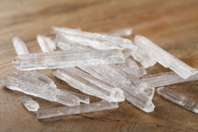 Photo of Menthol crystals on wooden background, closeup view