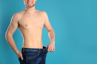 Photo of Young man in oversized jeans on color background, closeup. Space for text