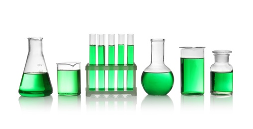 Photo of Laboratory glassware with green liquid on white background