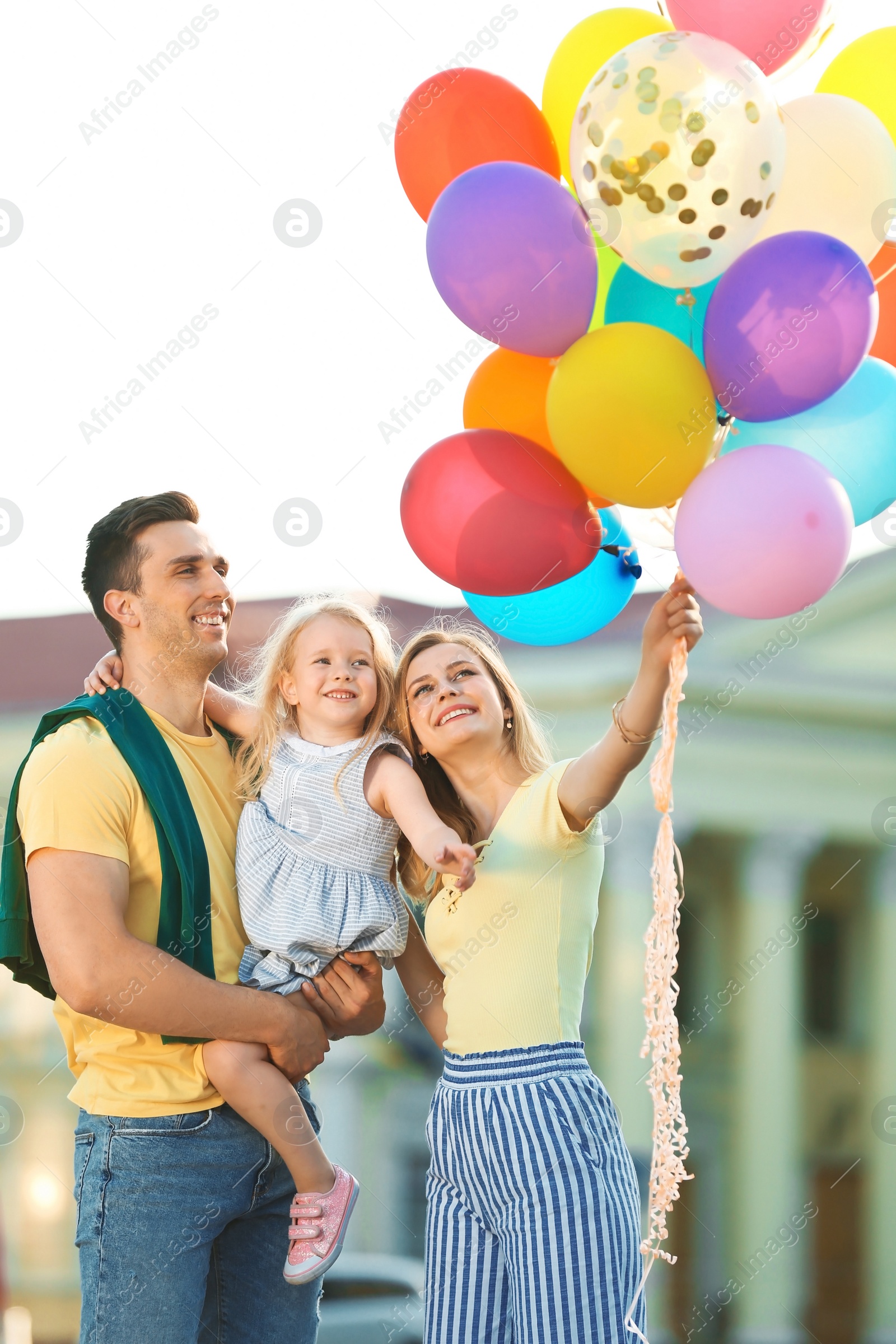 Photo of Happy family with colorful balloons outdoors on sunny day