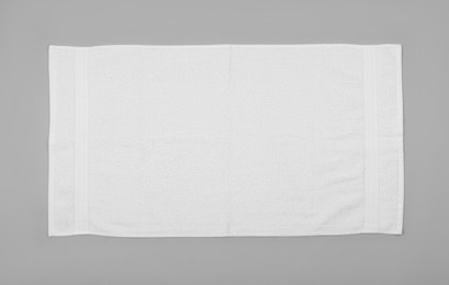 Photo of White beach towel on light grey background, top view