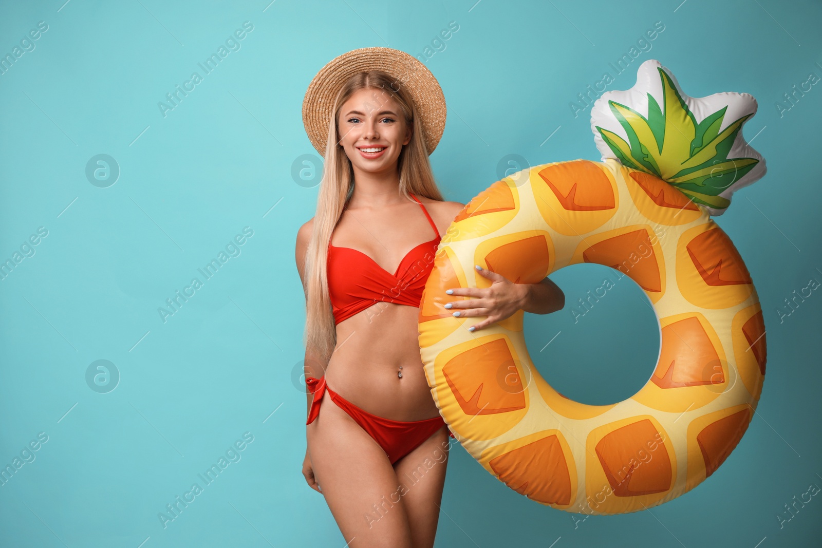 Photo of Pretty young woman wearing stylish bikini with inflatable ring on blue background