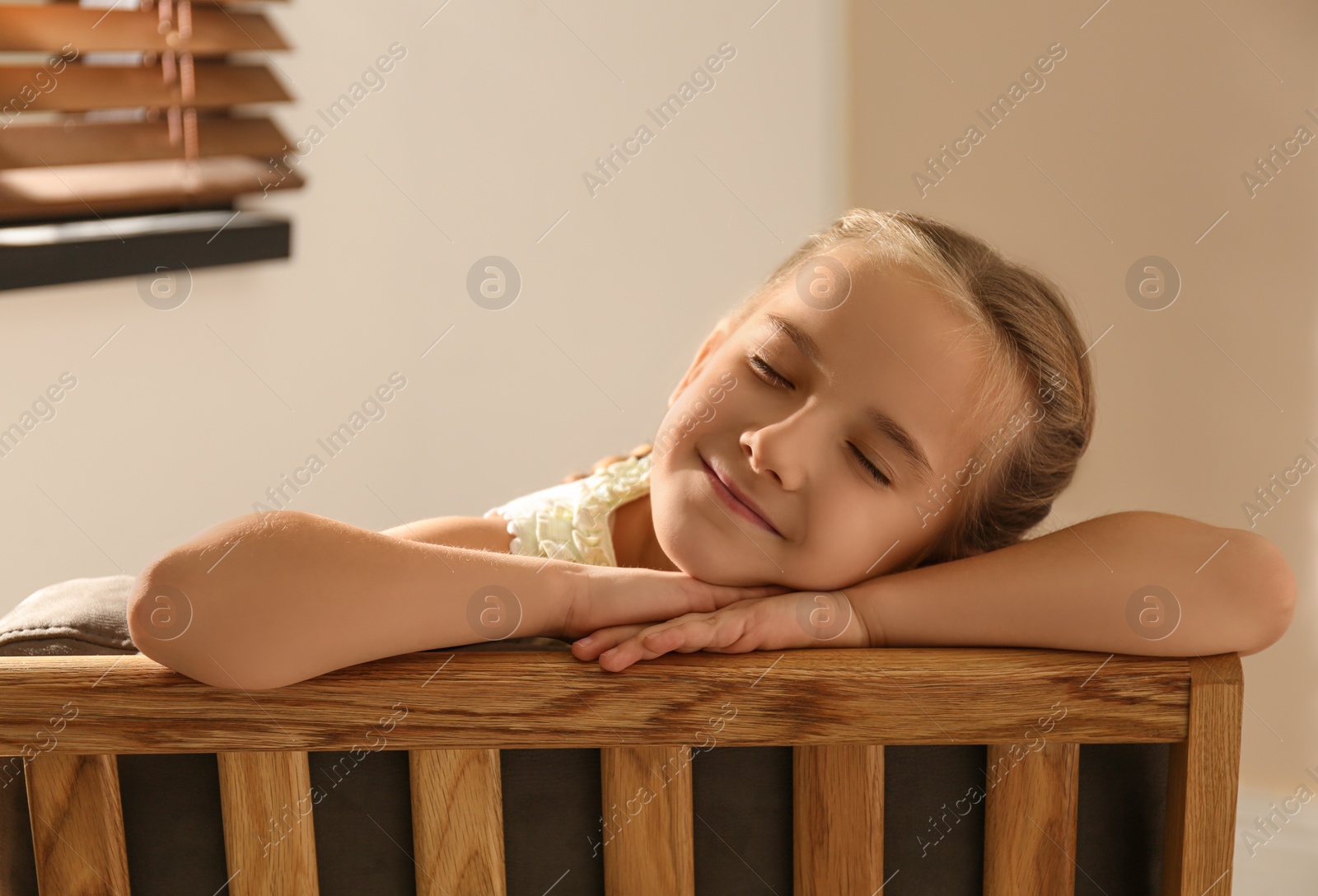 Photo of Little girl sleeping in armchair at home