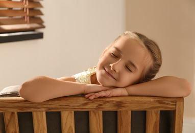 Photo of Little girl sleeping in armchair at home