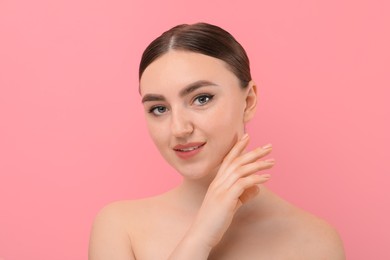 Makeup product. Woman with black eyeliner and beautiful eyebrows on pink background