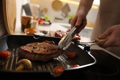 Man cooking meat with vegetables in frying pan, closeup