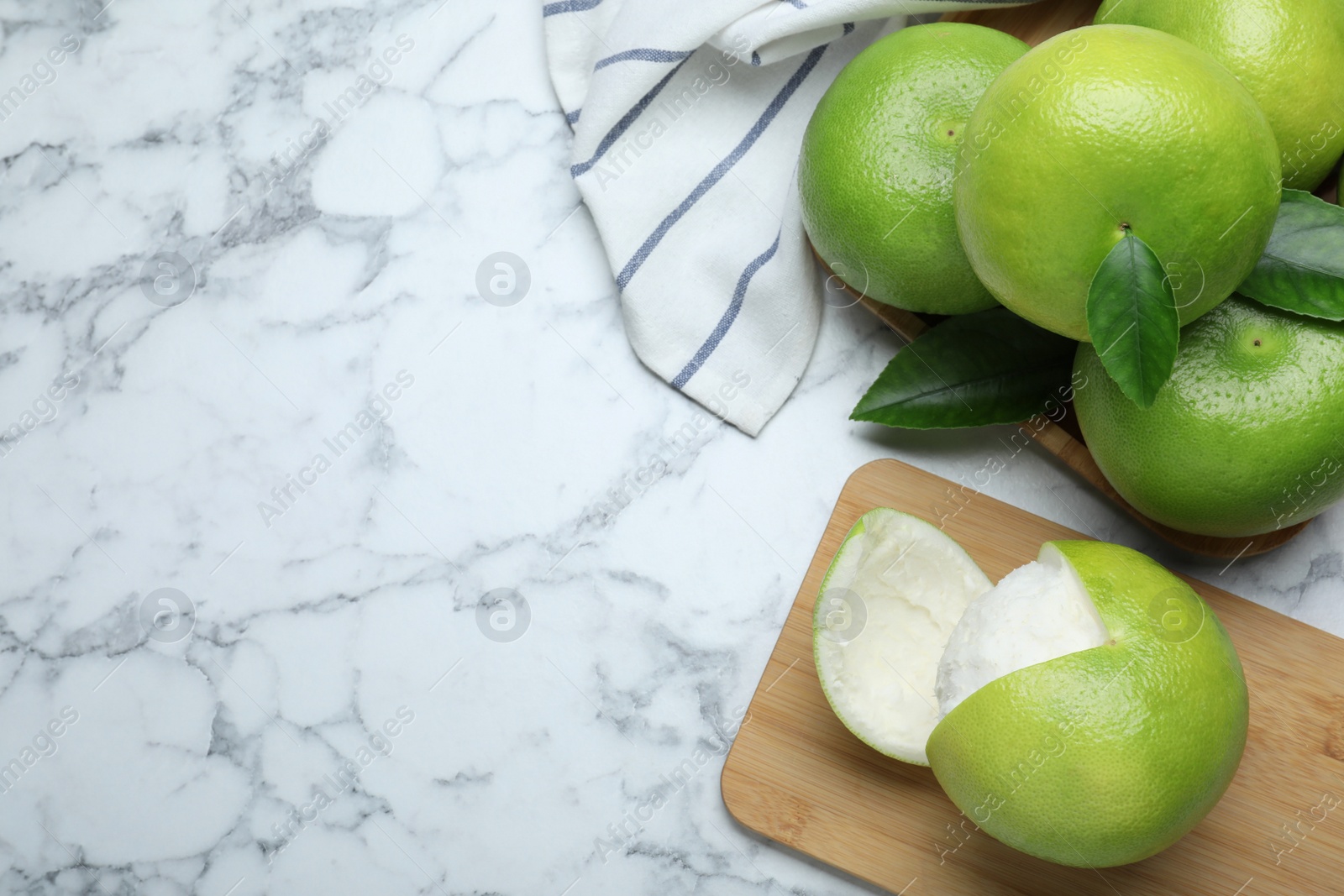 Photo of Fresh ripe sweetie fruits on white marble table, flat lay. Space for text