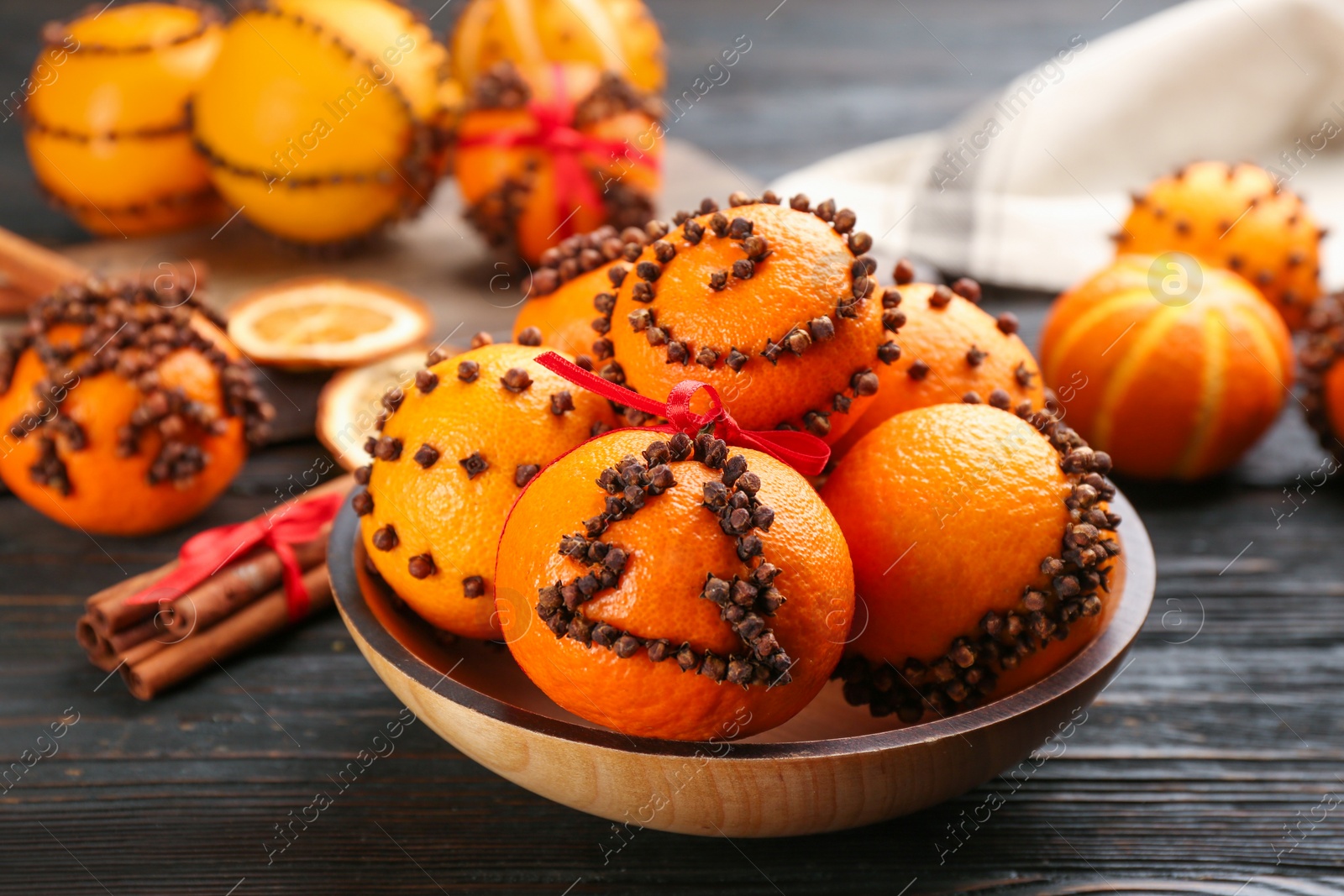 Photo of Pomander balls made of fresh tangerines and cloves on wooden table