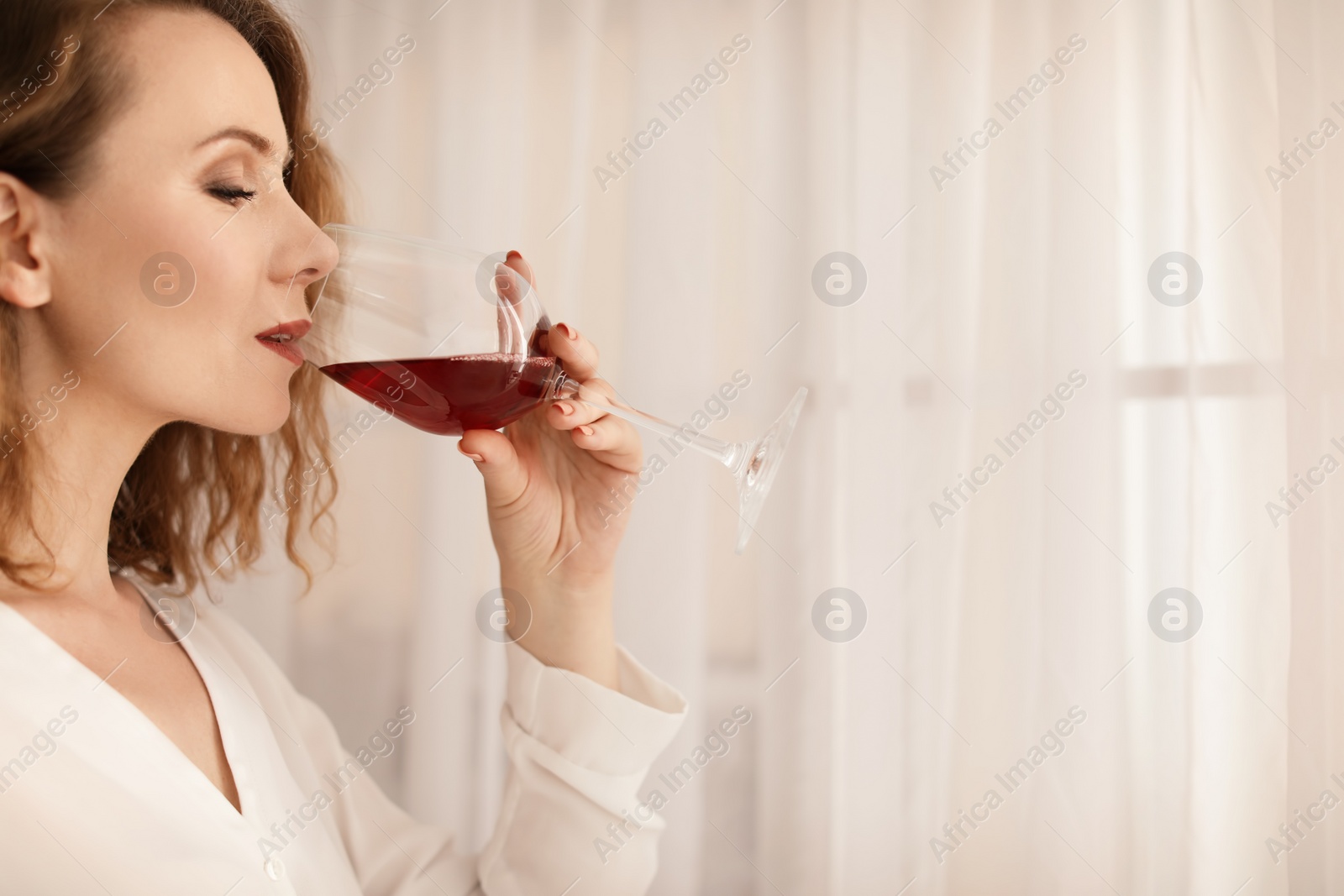 Photo of Woman with glass of delicious wine indoors