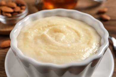 Photo of Delicious semolina pudding in bowl on table, closeup view