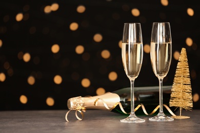 Photo of New year composition with champagne and space for text against blurred Christmas lights