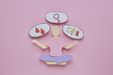 Photo of Woman`s health. Paper female figure and different stickers on pale pink background, flat lay