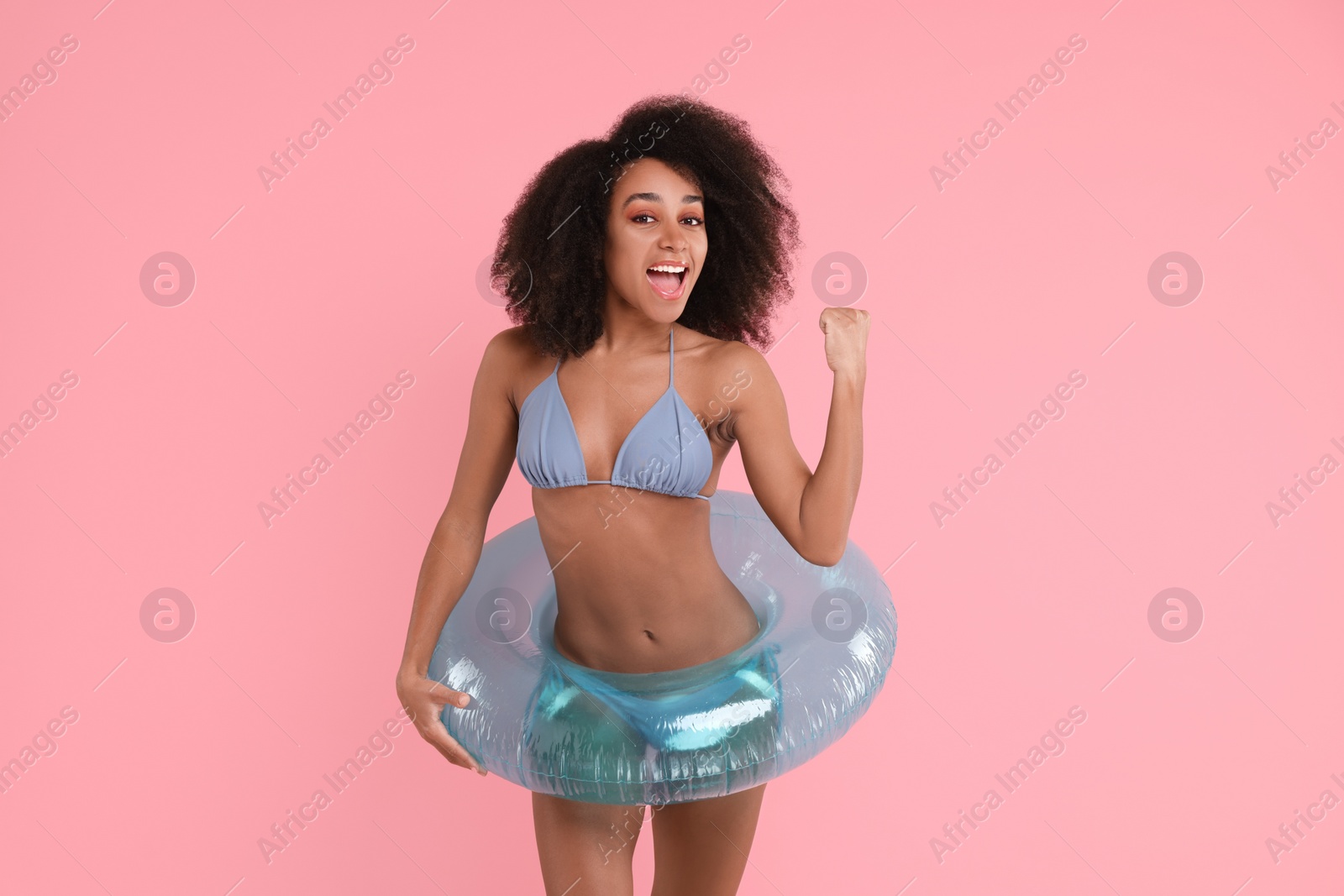 Photo of Beautiful woman in stylish bikini with inflatable ring on pink background