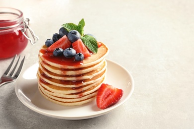 Photo of Plate with pancakes and berries on table