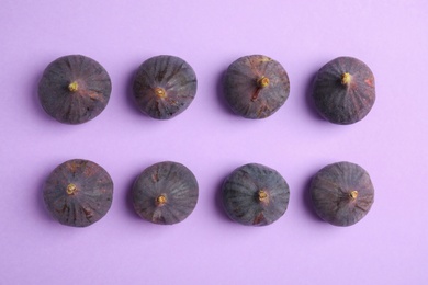 Photo of Delicious ripe figs on violet background, flat lay