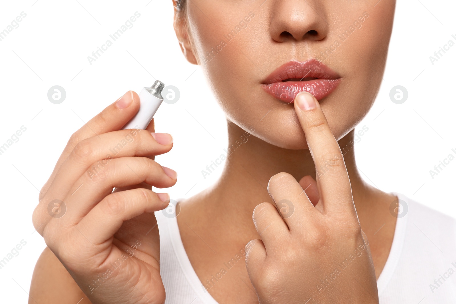 Photo of Woman with herpes applying cream on lips against white background, closeup