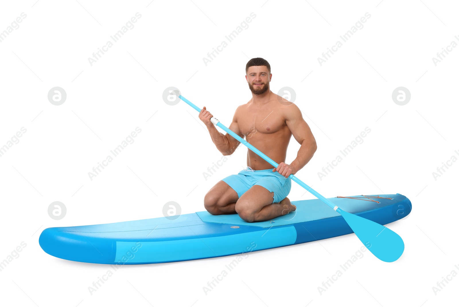 Photo of Handsome man with paddle on blue SUP board against white background