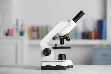 Photo of Modern medical microscope on white table in laboratory